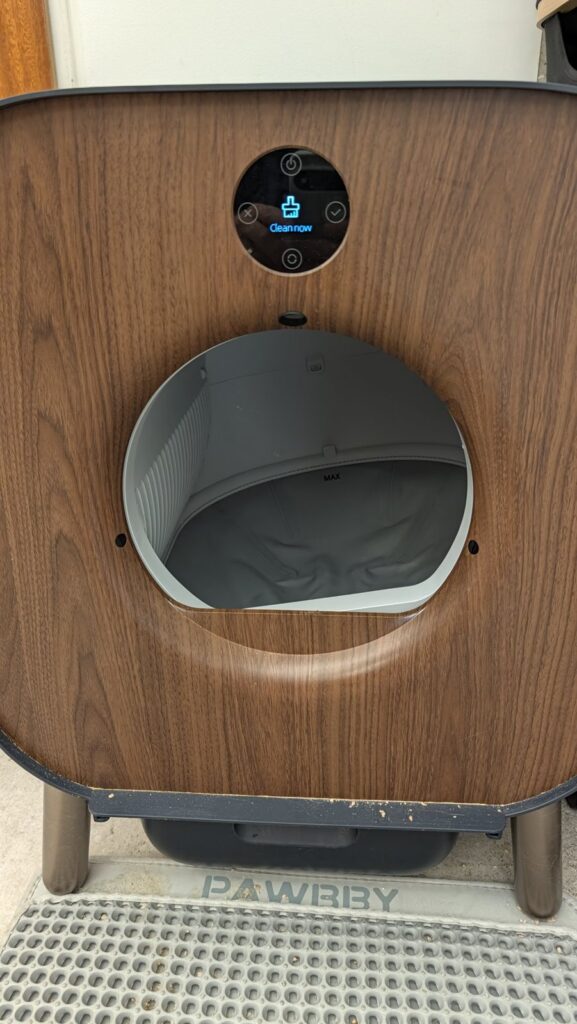 Round display of the PAWBBY litter box showing its Clean now option